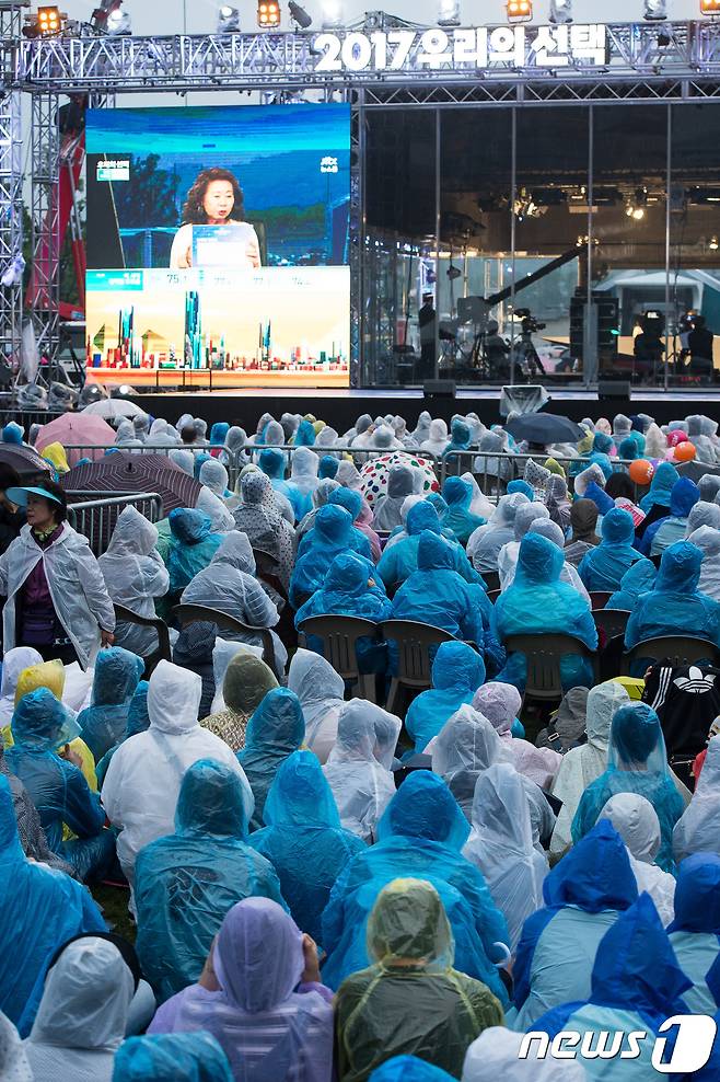 제19대 대통령선거일인 9일 서울 광화문광장에서 유권자들이 비옷을 입고 방송사 개표방송을 지켜보고 있다. 2017.5.9/뉴스1 © News1 유승관 기자