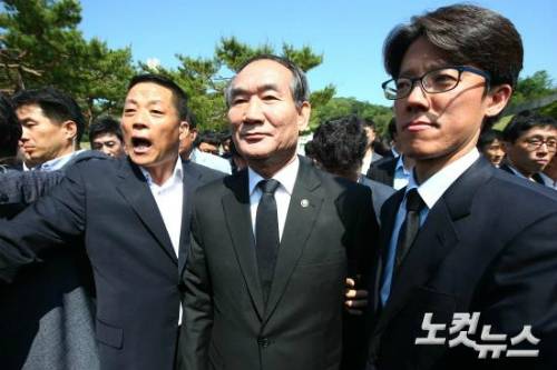 박승춘 전 국가보훈처장이 지난해 5월 18일 광주 북구 5·18 민주묘지에서 열린 5·18 민주화운동 36주년 기념식에서 임을 위한 행진곡 합창 결정에 항의하는 5·18 유가족들로 인해 행사장을 떠나고 있다. (사진=윤창원 기자)