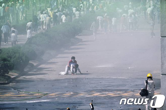 1987년 시위 도중 경찰이 쏜 최루탄에 맞고 쓰러져 숨진 이한열 열사의 모습이 담긴 사진 2점이 공개됐다. 당시 내셔널지오그래픽 사진기자로 한국을 찾은 네이션 벤은 6월 민주항쟁 30주년을 맞아 이한열기념사업회에 이 사진을 제공했다. 사진은 1987년 6월 9일 서울 연세대학교 정문에서 경영학과 2학년생이었던 이한열 열사가 최루탄에 맞아 쓰러져 도서관학과 2학년생 이종창씨가 뒤에서 부축하고 있는 모습. (네이션 벤 제공) 2017.5.20/뉴스1