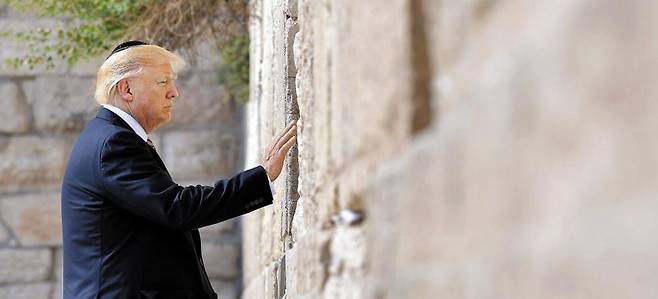 '통곡의 벽' 찾은 트럼프… - 현직 美대통령으로는 처음 22일(현지 시각) 이스라엘의 동(東)예루살렘을 방문한 도널드 트럼프 미국 대통령이 유대인의 성지‘통곡의 벽’을 찾아 유대교의 전통 모자인 검은색 키파를 쓰고 벽에 손을 얹고 있다. 미국의 현직 대통령 중‘통곡의 벽’을 찾은 것은 그가 처음이다. CNN 방송은“’통곡의 벽’이 있는 동예루살렘은 국제법상 팔레스타인 땅이지만 이스라엘이 사실상 점령하고 있다”며“트럼프 대통령이 이곳을 찾은 것은 이스라엘을 지지하는 것을 의미해 큰 논란을 일으킬 수 있다”고 보도했다. /AFP 연합뉴스