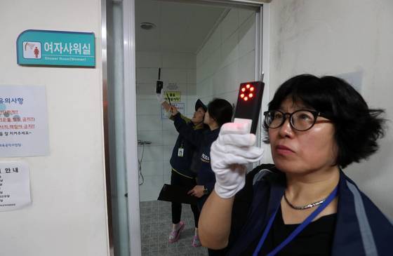 서울시 여성안심보안관 박광미(오른쪽)씨가 12일 서울 용산구 청파동 헬스장의 샤워실과 탈의실에서 적외선 탐지기의 불빛을 이용해 몰래 카메라를 탐지하고 있다. 김상선 기사