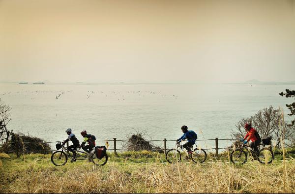 [월간산]외달도 서쪽 해변의 산책로를 달리는 자전거 동호인들. 2인승을 탄 황인석, 김진자씨 부부 뒤를 따르며 자전거 투어를 즐기는 김선자, 백은식씨.