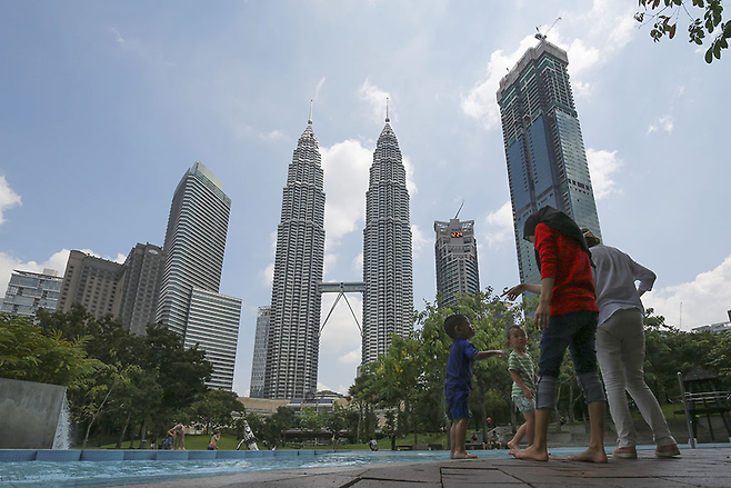 적극적인 외자 개방 정책으로 말레이시아는 아세안에서 싱가포르, 브루나이에 이어 세 번째로 잘사는 나라가 됐다. 쿠알라룸푸르 페트로나스 타워 앞에 있는 고급 빌라 내 수영장에서 아이들과 부모가 뛰어놀고 있다. ⓒ 사진=AP연합
