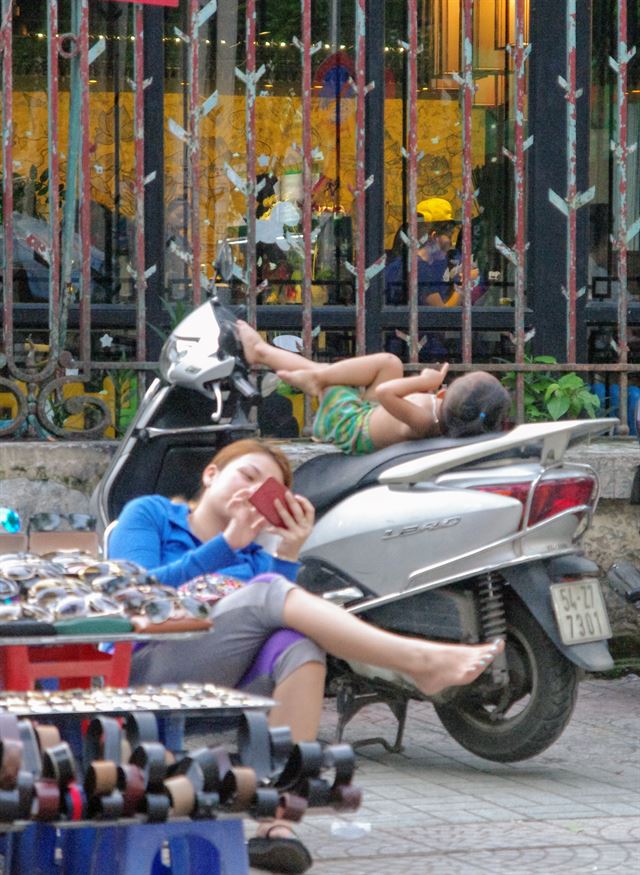 호찌민 시내 한 노점상 풍경. 엄마를 따라온 듯한 어린 아이가 오토바이 안장에 누워 놀고 있다.