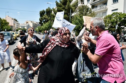 (아테네 AFP=연합뉴스) 시리아 난민들이 19일 그리스 아테네 주재 독일 대사관 앞에서 독일로 가는 것을 허용해달라며 시위를 벌이고 있다.