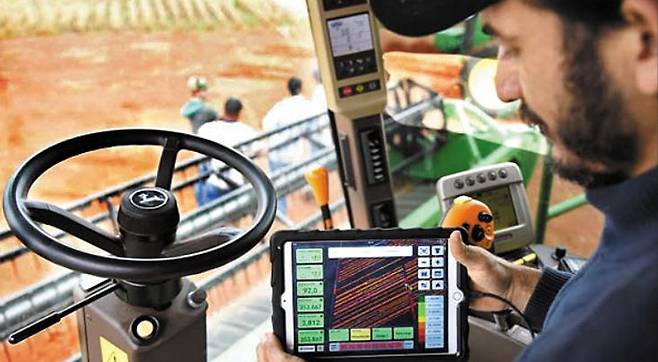 미국 일리노이주에서 트랙터를 운전하는 농부가 태블릿PC에 나타난 옥수수밭 상태를 살펴보고 있다. 인공지능과 빅데이터 분석 기법을 적용한 '처방 농법'은 생산 비용을 30% 줄이면서도 수확량은 25% 이상 늘리는 효과를 내고 있다. /몬산토