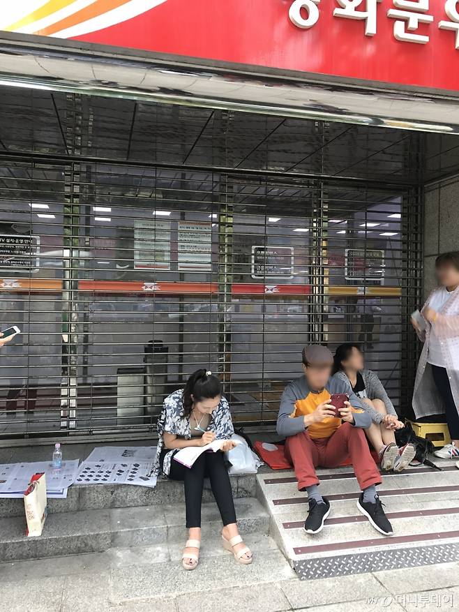 기념우표 판매를 기다리며 책을 펴고 공부하는 시민이 눈길을 끈다 /사진=신현우 기자