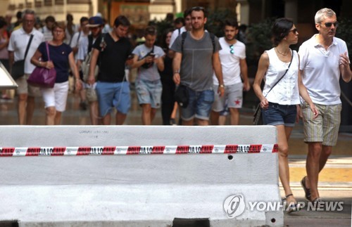 19일 차량 차단용 방벽이 설치된 밀라노 도심을 걷고 있는 시민들 [EPA=연합뉴스]