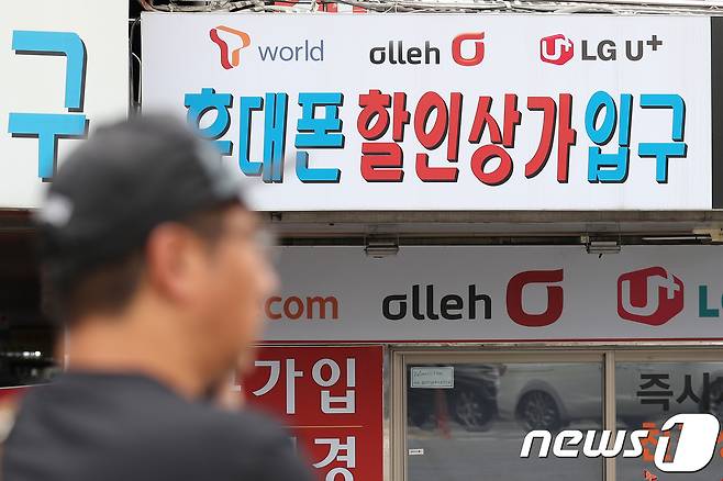 지난 16일 오후 서울 용산구의 한 핸드폰 판매업소 앞을 시민들이 지나고 있다.  © News1 임세영 기자