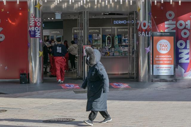 전국에 한파특보가 내려진 1일 서울 중구 명동거리에서 개문난방 중인 한 상점 앞으로 두꺼운 옷차림의 시민이 지나가고 있다.