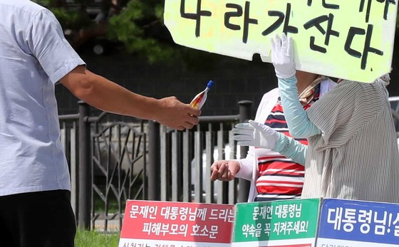 청와대 외곽 경호를 담당하는 경찰관이 1인 시위자들을 찾아다니며 시원한 음료를 건네주고 있다. 김상선 기자