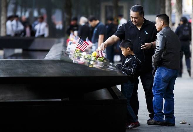 9.11 테러 희생자 가족들이 11일(현지시간) 뉴욕에서 열리는 9ㆍ11 테러 16주기 추모식 참석에 앞서 희생자들을 추모하고 있다.[EPA=연합뉴스]