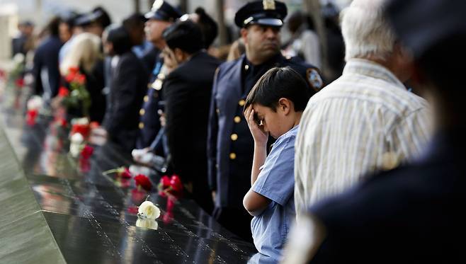 9ㆍ11테러 16주기를 맞은 11일(현지시간) 미국 뉴욕의 9ㆍ11 테러 추모공간 ‘그라운드 제로’에서 한 어린이가 슬픔에 잠겨있다. [EPA=연합뉴스]