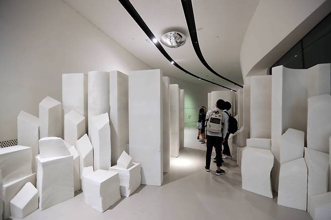 "가까이 있어 보이지 않던 소중함" 이라는 글자가 천장에 매달린 볼록거울에 비치고 있다. 아래에서는 아무런 의미 없이 쌓아 놓은 것처럼 보인다. 신인섭 기자