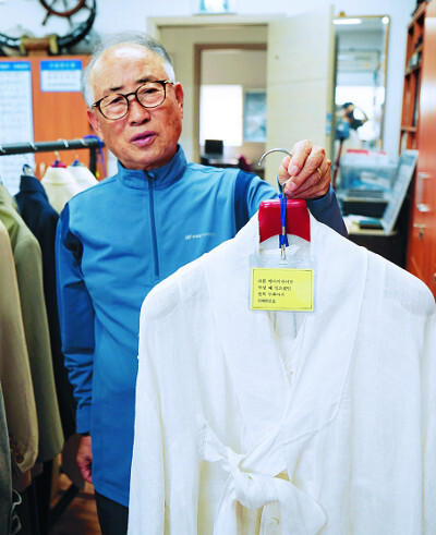 김용기 장로의 아들 김평일 가나안농군학교 교장이 아버지가 막사이사이상 수상식 때 입은 삼베옷을 보여주고 있다.
