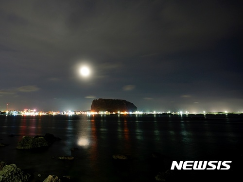 【제주=뉴시스】제주 서귀포시 성산읍 성산일출봉 위로 달이 떠오르는 모습. 바다 위에 은은히 비치는 달빛이 아름답다. (사진=뉴시스DB)