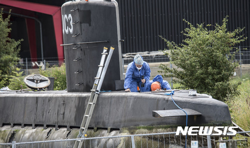【코펜하겐( 덴마크) = AP/뉴시스】 = 지난 8월 14일 덴마크 경찰이 코펜하겐의 한 부두에서 발명가 페터 마드센이 손수 만든 잠수함에 대한 압수수색을 하고 있다.  코펜하겐 경찰은 10월 7일  실종된 스웨덴 여기자 킴 발의 시신 일부가 추가로 발견되었다고 발표했다.