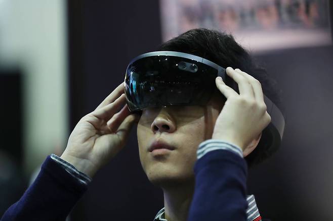 전시장을 찾은 시민이 슈어소프트가 개발한 스마트팩토리의 홀로 렌즈를 체험해 보고 있다. 증강 현실을 이용해 사용자가 렌즈를 착용하면 위치 정보 등을 확인할 수 있다. 우상조 기자