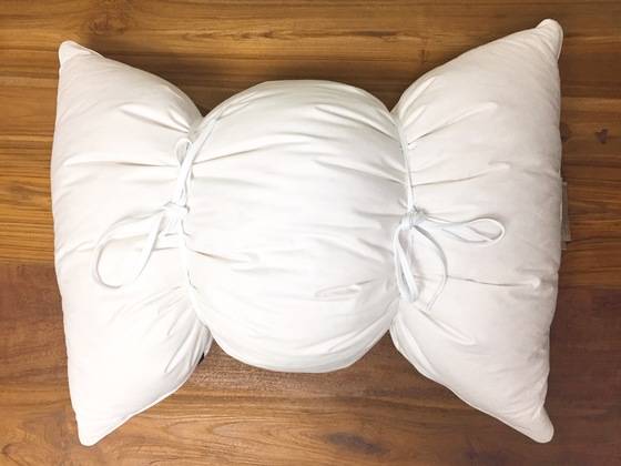 흰 운동화 끈으로 삼등분해 묶은 베개. 이 상태로 세탁기에 넣으면 된다.