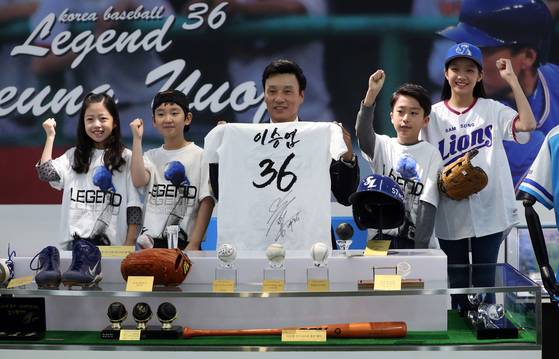 이승엽 선수가 15일 서울 용산 아이파크백화점에서 열린 은퇴기념 전시회 개막식에 참석해 어린이 팬들에게 선물할 '사인 티셔츠'를 보여주고 있다. 박종근 기자