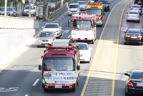 (서울=연합뉴스) 동대문소방서가 17일 오후 동대문구 10km 일대에서 소방차 길 터주기 국민 참여 훈련을 하고 있다. [동대문소방서 제공=연합뉴스]