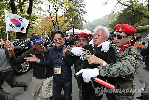 (서울=연합뉴스) 이정훈 기자 = 자유한국당 류석춘 혁신위원장이 26일 오전 서울 동작구 국립서울현충원 박정희 전 대통령 묘역에서 열린 제38주기 추도식에서 박 전 대통령 지지자들에게 쫓겨나고 있다.      uwg806@yna.co.kr