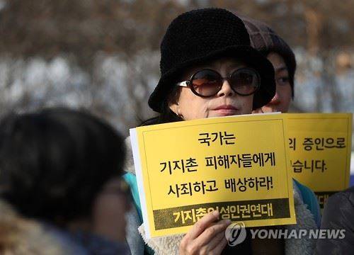 지난 1월 20일 서울 서초구 서울중앙지방법원 앞에서 열린 '한국 내 기지촌 미군 위안부 국가손해배상청구 소송 1심 판결에 대한 기자회견'에 참석한 여성들이 국가 배상을 촉구하는 팻말을 들고 있다. 연합뉴스