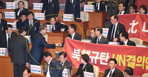 문재인 대통령이 1일 오전 국회 본회의장에서 2018년도 예산안 시정연설을 마친 뒤 현수막 시위를 벌이고 있는 한국당 의원들과 인사를 하며 퇴장하고 있다. [연합뉴스]