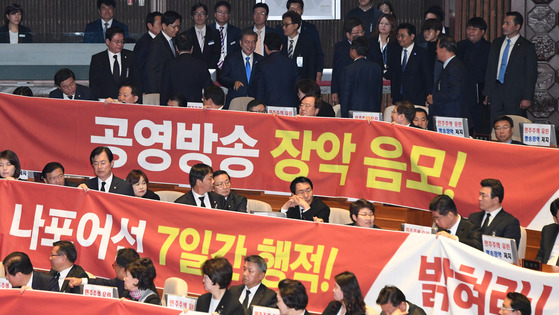 문재인 대통령이 1일 오전 국회 본회의장에서 2018년도 예산안 시정연설을 마친 뒤 현수막 시위를 벌이고 있는 한국당 의원들과 인사를 하며 퇴장하고 있다. [연합뉴스]