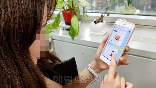한 고객이 모바일앱을 통해 피자를 주문하고 있다.