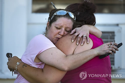 (샌안토니오 AP=연합뉴스) 총기 난사 사건이 발생한 미국 텍사스주 샌안토니오 인근 서덜랜드 스프링스의 서덜랜드 스프링스 제1침례교회 인근에서 5일(현지시간) 주민들이 서로 부둥켜안고 비통해하고 있다.     ymarshal@yna.co.kr