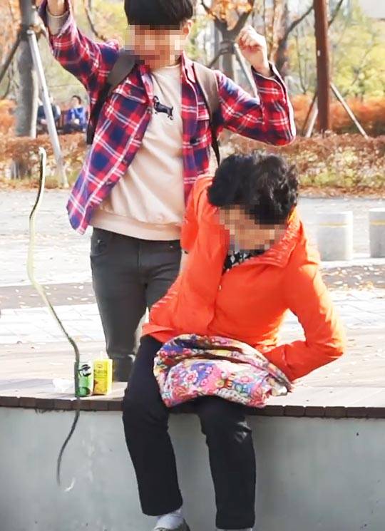 ‘몰카 오락’을 만드는 한 1인 미디어 제작자가 공원에 앉아 있는 노인들에게 가짜 뱀을 던져 놀라게 하고 있다. /유튜브