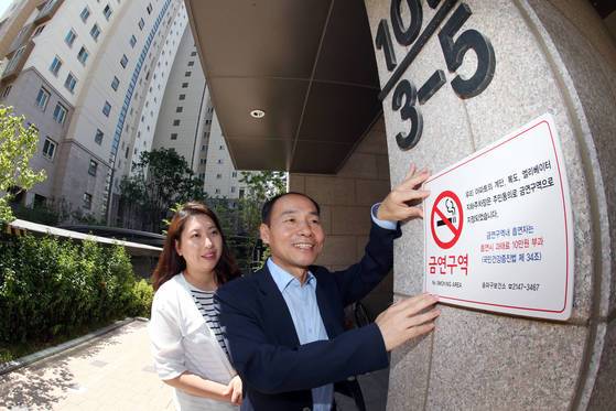 지난 6월 금연 아파트로 지정된 서울 송파구 한 아파트 단지에서 금연 스티커를 부착하고 있다. [중앙포토]