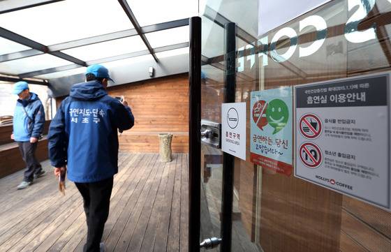 서초구 금연지도단속 공무원들이 관할구역 내 커피전문점 흡연실을 둘러보고 있다. 4~6명의 단속원이 관할구역 내 금연아파트를 포함한 금연구역 전체를 빈 틈 없이 단속하기란 사실상 불가능하다. [중앙포토]