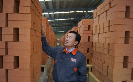 한삼화 회장이 포장을 앞둔 황토벽돌을 점검하고 있다. [사진 삼한C1 제공]