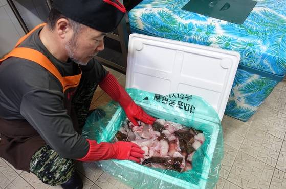 주인 홍탁근씨가 부산수협 다대포공판장에서 경매 받아 내장 분리하고 초벌 손질해 얼음 채워 보낸 상자를 열어 아귀를 살펴보고 있다.
