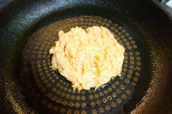 늙은 호박 채를 밀가루 반죽에 섞어 전을 부치려고 팬에 올렸다.