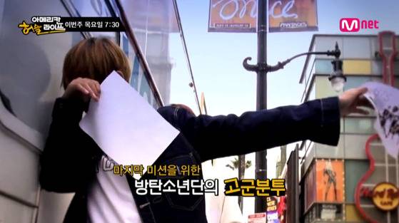 전단지를 돌리는 방탄소년단. [사진 Mnet 방송화면]