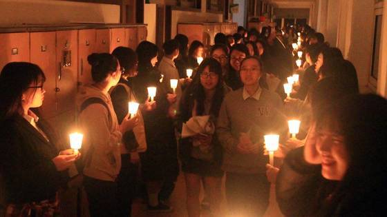 "선배님, 시험 잘보세요." 지난 10일 오후 속초여자고등학교에서 1,2학년 후배들이 촛불을 들고서 선배들의 수능시험을 응원하고 있다. [연합뉴스]