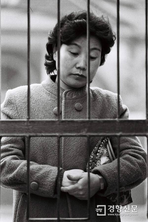 1984년 11월 23일 한 학부모가 대학입학 학력고사장 앞에서 기도를 하고 있다. 경향신문 자료사진