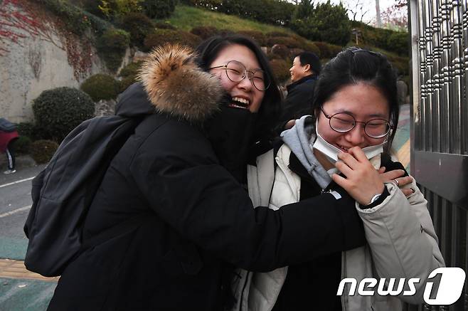 경북 포항지역 지진으로 일주일 연기된 2018학년도 대학수학능력시험일인 23일 오후 부산 해운대구 해운대여자고등학교에서 수능을 마친 수험생들이 가족과 포옹을 하고 있다. 2017.11.23/뉴스1 © News1 여주연 기자