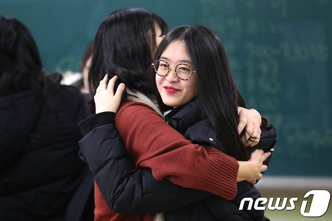 24일 오전 서울 서초구 서초고등학교에서 한 고3 수험생이 2018학년도 수능 가채점을 끝내고 선생님과 포옹을 하고 있다. 2017.11.24/뉴스1 © News1 성동훈 기자