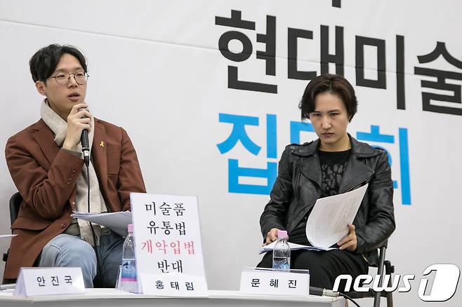 홍태림 미술평론가(왼쪽)가 24일 서울 중구 서소문동 서울시립미술관 서소문본관 세마홀에서 열린 한국 현대미술 비평 집담회 도중 '미술품 유통법 개악입법 반대' 퍼포먼스를 펼치고 있다. 2017.11.24/뉴스1 © News1 박정환 기자