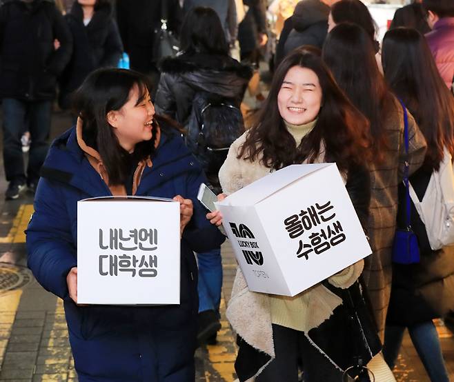 2018학년도 대학 수학능력시험이 끝난 23일 저녁 서울 중구 명동거리에서 시험을 마친 수험생들이 ‘올해는 수험생, 내년엔 대학생’이라고 적힌 상자를 든 채 환하게 웃고 있다. /연합뉴스