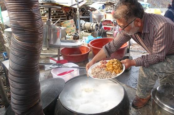 콩즙이 끓자 박기영 시인이 다져서 소금 뿌려둔 꿩고기를 솥에 넣고 있다.