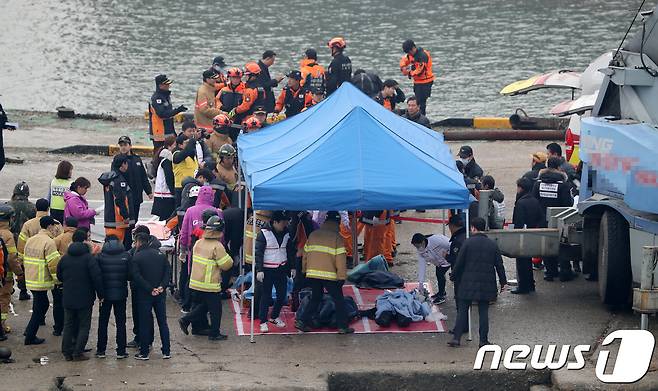 3일 오전 인천해경과 119 구조대원들이 인천 옹진군 영흥도 앞바다에서 낚싯배 전복사고 현장에서 구조된 사람들과 사망자를 영흥도 진두선착장으로 옮기고 있다. 이날 오전 6시12분께 인천 옹진군 영흥도 영흥대교 인근 남방 5마일 해상에서 낚싯배가 급유선과 충돌해 전복되는 사고가 발생했다. 2017.12.13/뉴스1 © News1 성동훈 기자
