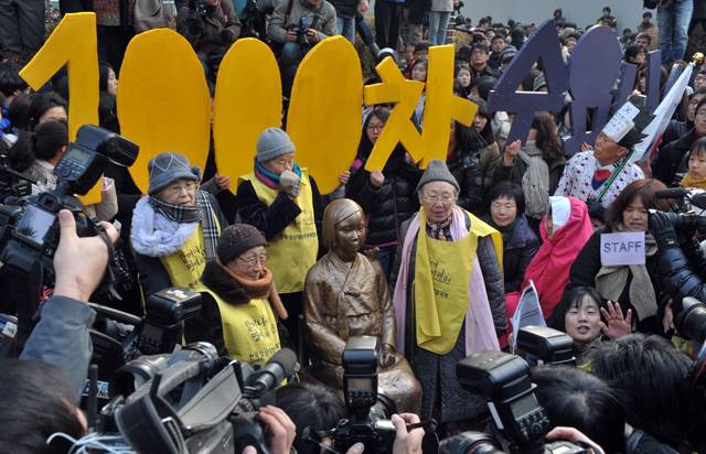 2011년 12월 14일, 서울 중학동 주한일본대사관 앞에서 열린 '제 1000차 수요집회'에 참석한 위안부 피해자 할머니들이 소녀상과 함께 서 있다. /조선DB