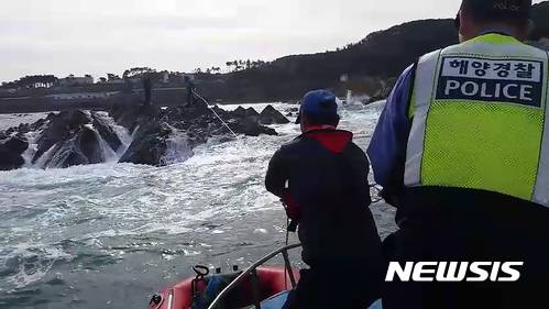 【울산=뉴시스】안정섭 기자 = 12일 오전 울산 울주군 진하해수욕장 인근 해상에서 울산해양경찰서 관계자들이 갯바위에 고립돼 있던 낚시객 2명을 구조하고 있다. 2017.11.12. (사진=울산해양경찰서 제공) photo@newsis.com