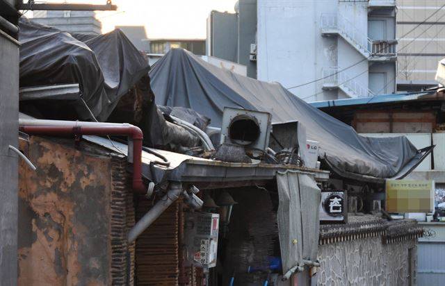 지붕에 멍에처럼 덧씌워진 천막은 전통문화가 밀려나면서 골목 상권마저 위협받는 인사동의 현실을 상징한다.