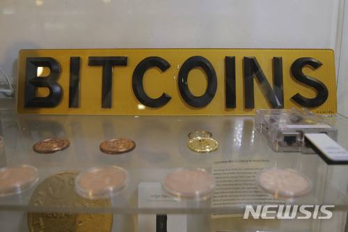 【홍콩=AP/뉴시스】 8일 홍콩에서 가상화폐 비트코인의 ATM 기 옆에 코인과 표시판이 전시되어 있다. 홍콩은 이 현금자동지급기로 가상화폐를 사용하고 있고 10일 미국에서 비트코인의 선물시장 거래가 시작됐다. 2017. 12. 11.